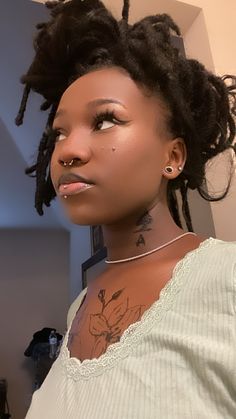 a woman with dreadlocks standing in front of a mirror and looking at the camera