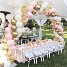 a table set up for a party with pink and gold balloons