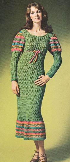 a woman in a green knitted dress standing with her hands on her hips