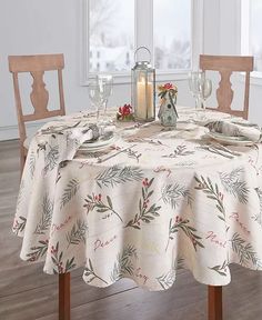 a dining room table set for four with place settings and candles on the table in front of it