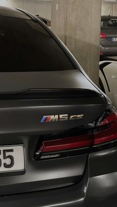 the back end of a bmw car parked in a parking garage next to other cars