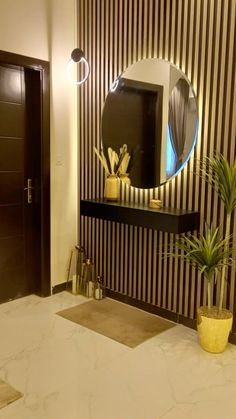 a bathroom with a mirror, potted plant and sink in front of striped wallpaper