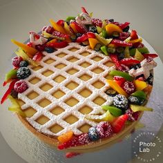 a waffle cake topped with fresh fruit and powdered sugar