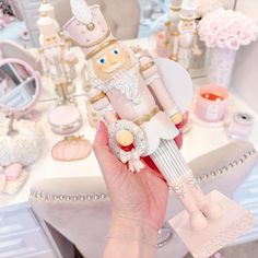 a person holding a toy in front of a table with flowers and other items on it