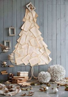 a christmas tree made out of books on top of a wooden table next to other items