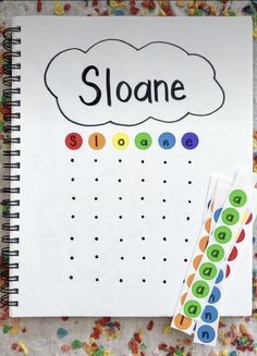 a spiral notebook with the word sloane written on it next to a sticker