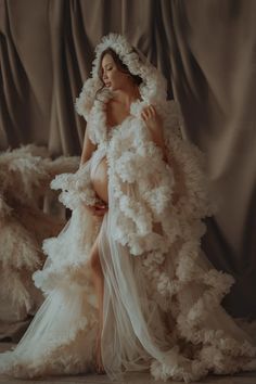 a woman in a white dress with feathers on her head and legs, posing for the camera