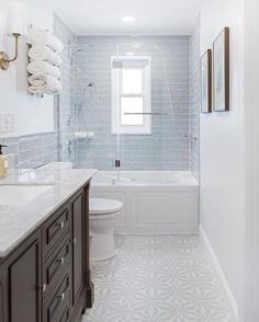 a white and gray bathroom with tile flooring