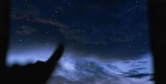 the night sky with stars and clouds is seen through a window at someone's hand