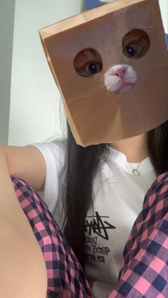 a woman wearing a paper bag over her head with a cat's face on it