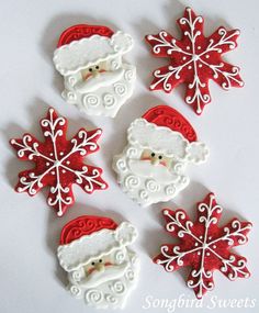 four decorated cookies with santa claus and snowflakes