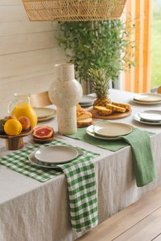 the table is set with plates and fruit