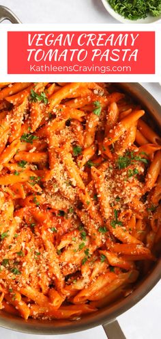 vegan creamy tomato pasta in a pan with parmesan cheese and herbs on top