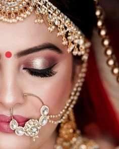 a close up of a woman with makeup on her face and jewelry around her neck