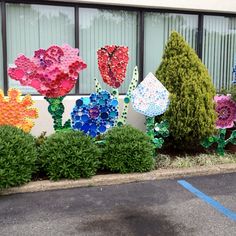 there are many flowers made out of plastic bottle caps on the side of this building