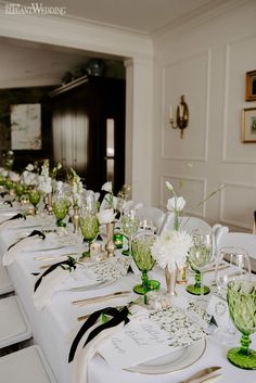 a long table is set with green and white place settings