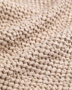 the texture of a knitted blanket is beige