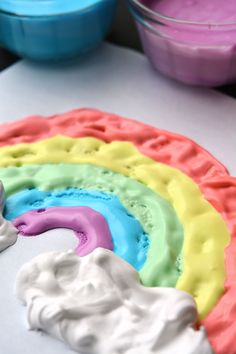 a rainbow cake with white frosting and blue icing