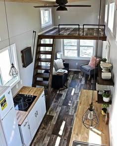 the interior of a tiny home with stairs leading up to the loft and living room