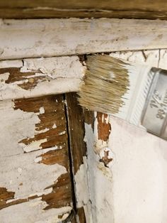 a paintbrush is being used to paint an old wooden wall