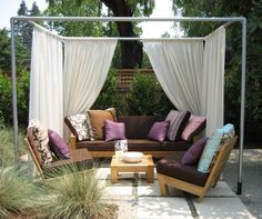 an outdoor living area with couches, chairs and a canopy over the fire pit