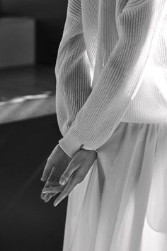 black and white photograph of a woman's hand on her hip, wearing a long skirt