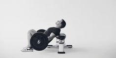 a man laying on top of a bench with a weight machine in front of him