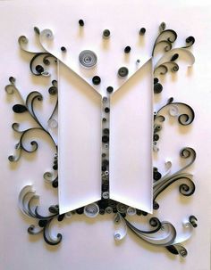 a clock made out of white and black paper with swirly designs on the face