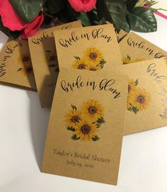 four sunflowers are on top of brown tags with the names of their guests