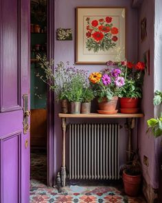 a purple room with potted plants on the radiator and a painting above it