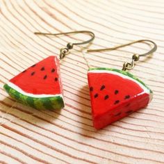 two slices of watermelon are hanging from earrings