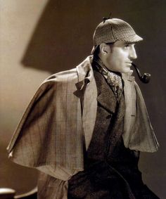 an old photo of a man wearing a suit and hat with a pipe in his mouth