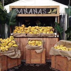 bunches of bananas are on display at an outdoor fruit stand with burlocks