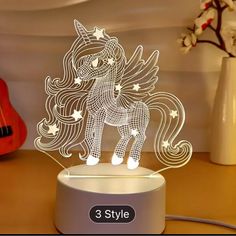 an illuminated unicorn on a table next to a guitar