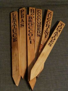 four pieces of wood that have been carved into the names of different people on them