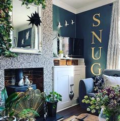 a living room filled with furniture and plants on top of a wooden table next to a fire place