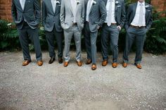 a group of men standing next to each other wearing suits and ties with flowers on them