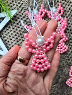 a person holding some pink beads in their hand