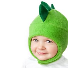 a young child wearing a green hat and smiling