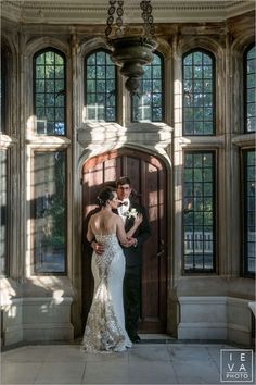 a bride and groom standing in front of a door