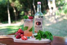 a bottle of tiki's next to some strawberries on a cutting board