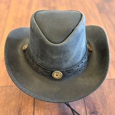 This hat is crafted from Crazy Horse Leather and features a braided band with conchos.  It includes a sweatband on the inside for comfort. Made with handcrafted leather for both men and women.  Its available in both tan and black natural leather colors.  It is unlined on the inside.  The wide brim of this leather hat provides shade in the sun.  You can make your own style as the brim of the hat is easily shapable. It is made from 100% pure leather. The hat is approximately 3" brim and 3 ½'' Crown in size. It has a distressed finish on all the leather.  It includes a chinstrap which is removable and adjustable to the customer's preference.  Please refer to the size chart as shown in the pictures to select the perfect size for you and to place an order with confidence. Rugged Leather Hat Bands, Rustic Leather Hat For Western-themed Events, Rustic Leather Hat Bands For Outdoor, Rugged Adjustable Leather Hat, Adjustable Rugged Leather Hat, Rustic Leather Fedora With Adjustable Fit, Western Style Hat With Leather Patch For Outdoor, Western Hats With Leather Patch For Outdoor, Western Outdoor Hat With Leather Patch