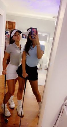 two women taking a selfie in the mirror with their crutches and tennis rackets