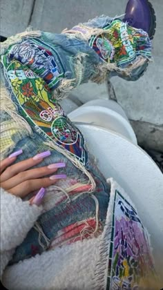 a woman's hand on the back of a motor scooter with colorful nail polish