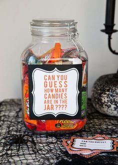 a jar filled with candy sitting on top of a table next to a halloween decoration