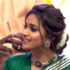 a woman is smiling while getting her hair done