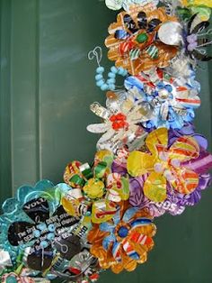 a bunch of glass beads hanging from the side of a green door in front of a building