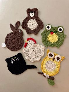 four crocheted animals and one black cat