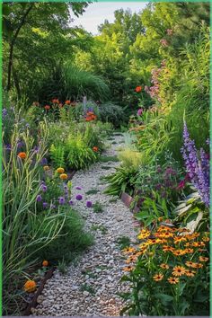 a garden filled with lots of different types of flowers and plants on top of gravel