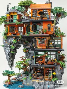 a lego house built into the side of a cliff with trees and plants on top